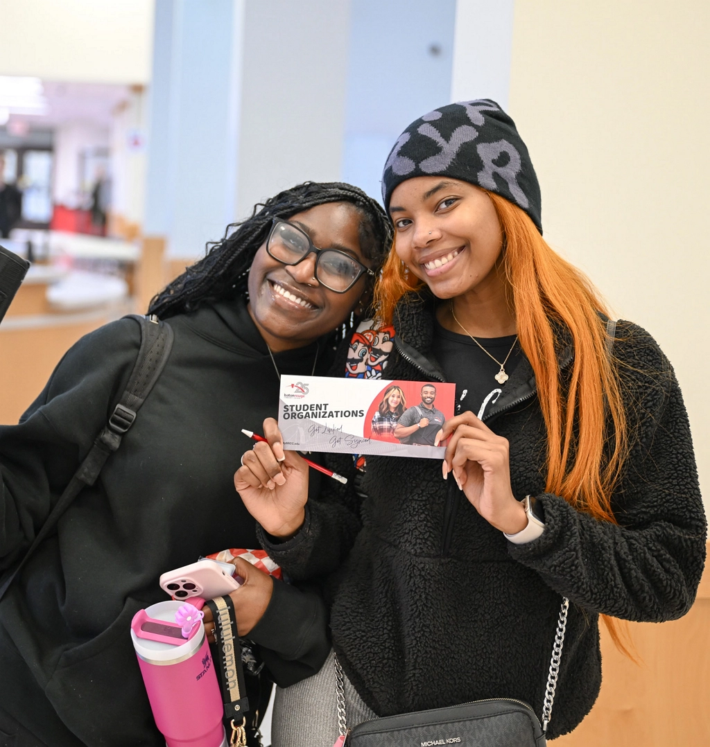 Two students smiling at student org fair.