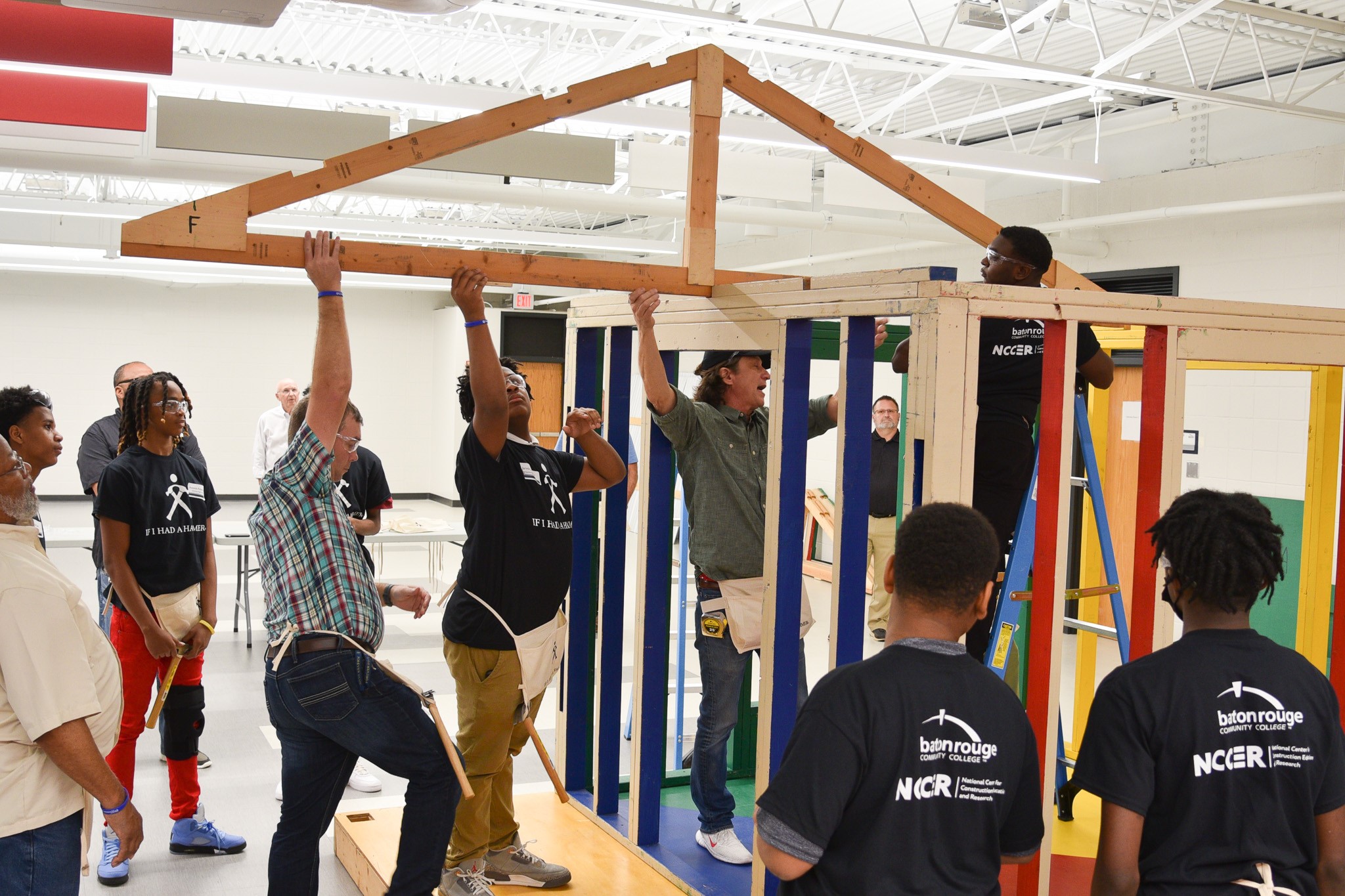 Participating Istrouma High School students work with master carpenter Perry Wilson on the Hammer House Build Experience at Baton Rouge Community College.