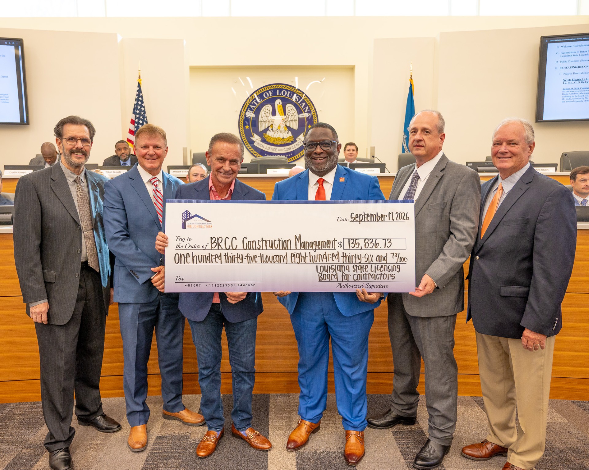 Chancellor Smith and Gery Frie receive a check from members of the Louisiana State Licensing Board for Contractors